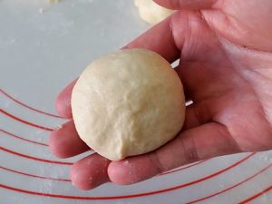 Showing finished shaped dough ball in hand