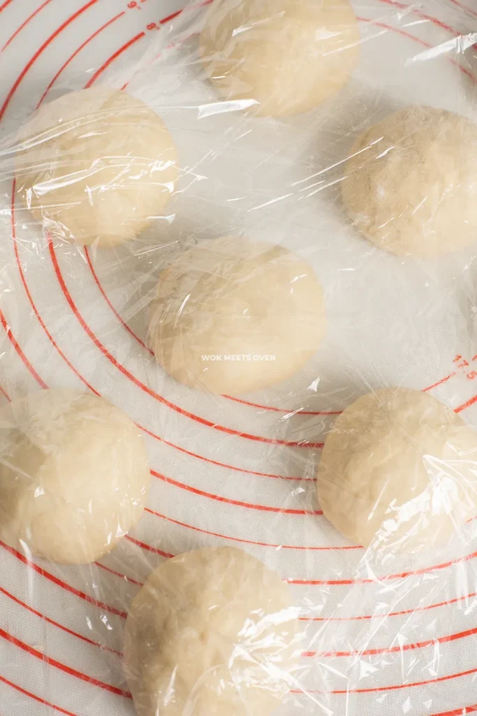 Covering dough balls with plastic wrap