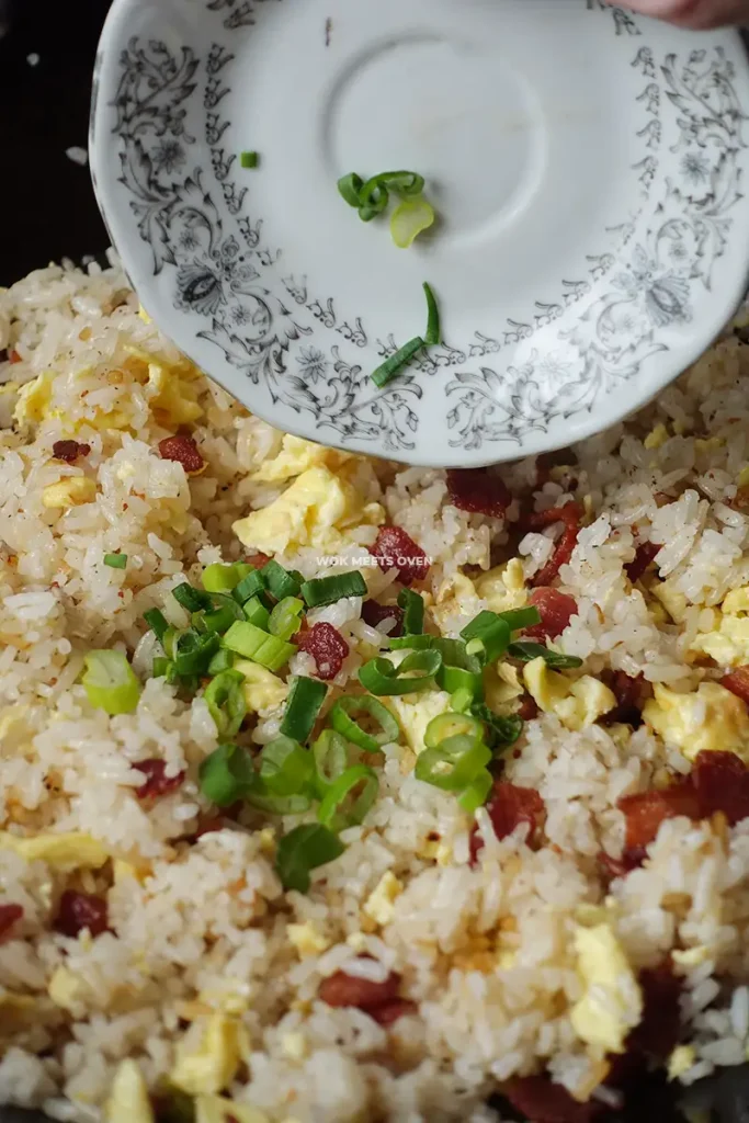 Adding in green onions to garnish fried rice