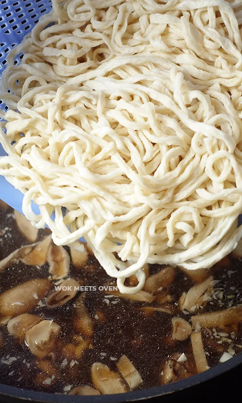 Adding in e-fu noodles to wok