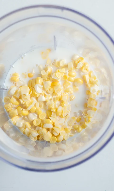 Adding in corn and milk into blender