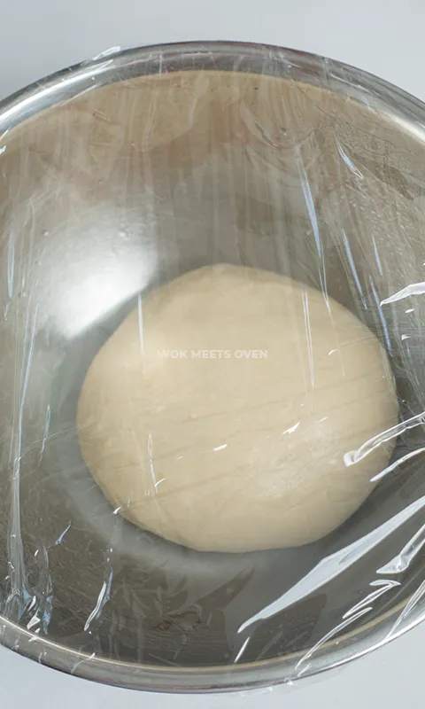 Covering dough with plastic wrap
