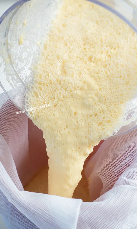 Adding in blended kernels and milk into cheese cloth bag