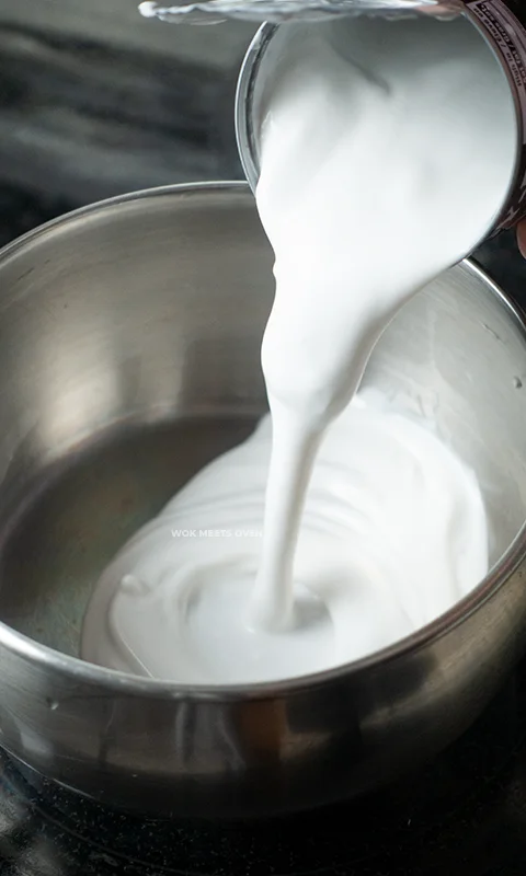 Adding in coconut milk into pot