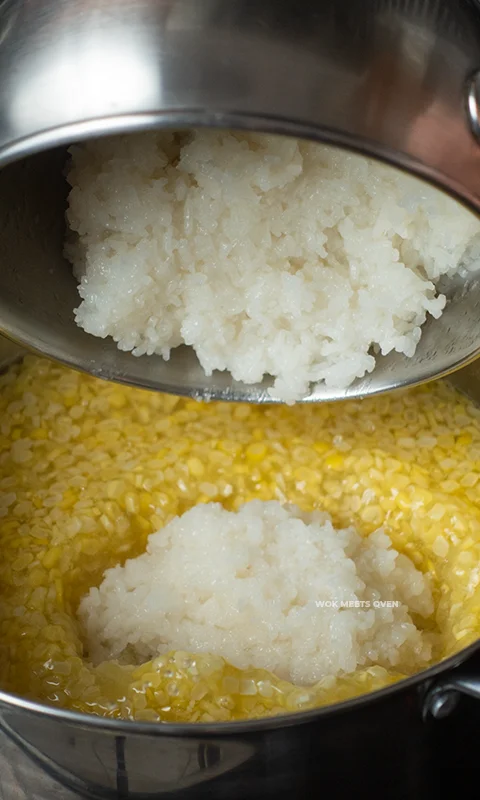 Adding in cooked glutinous rice with corn in pot