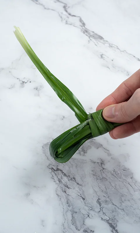 Wrapping one end of Pandan leave on bunch