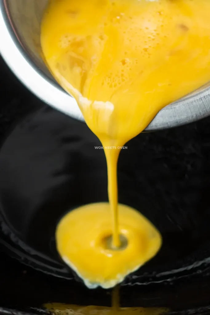 Pouring in eggs into wok