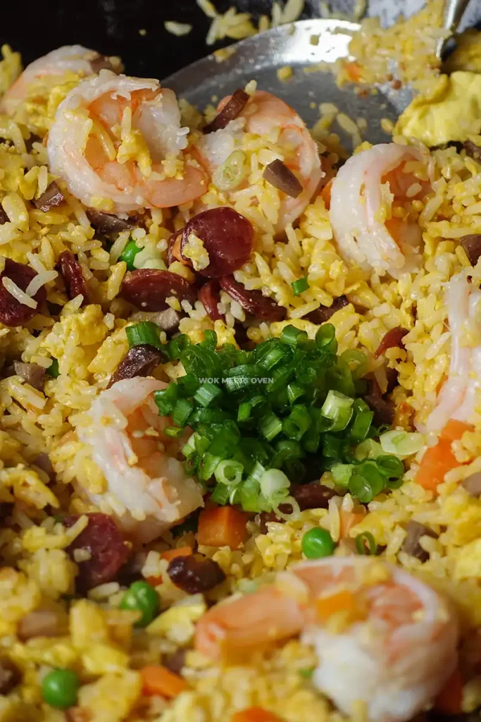 Adding in green onions to fried rice