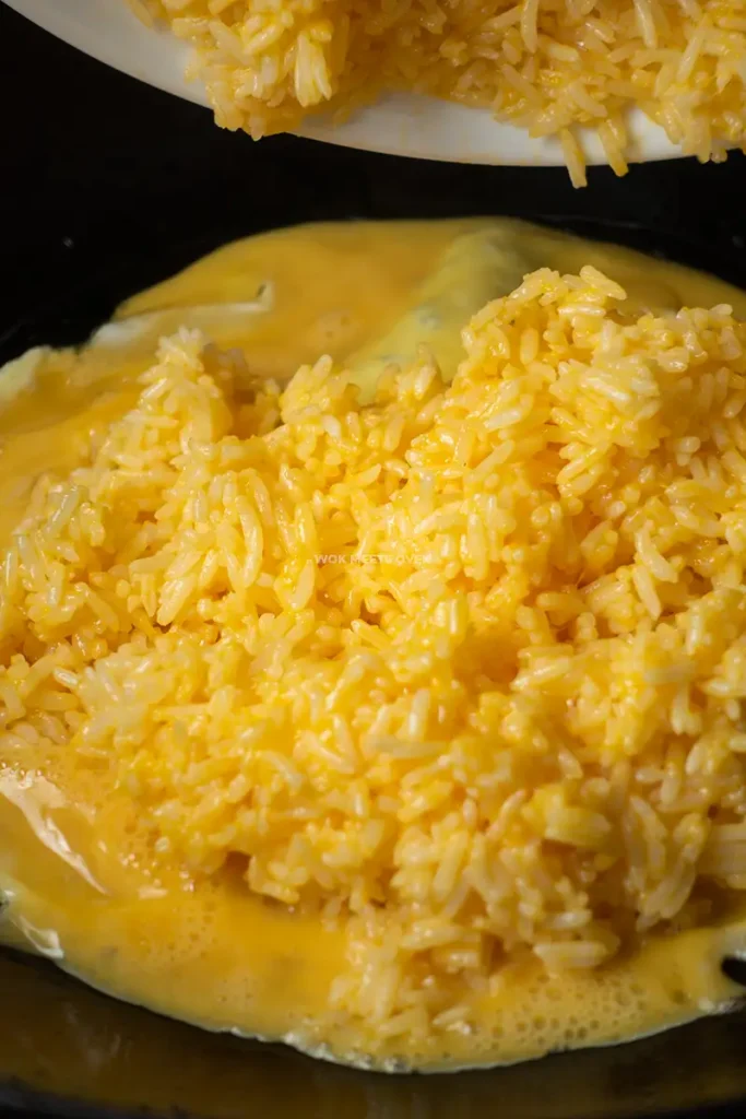 Adding in rice on top of eggs
