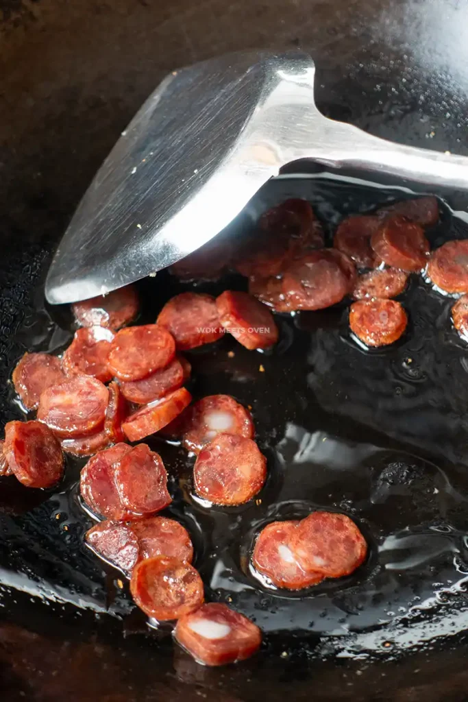 Stir-frying Chinese sausage in wok