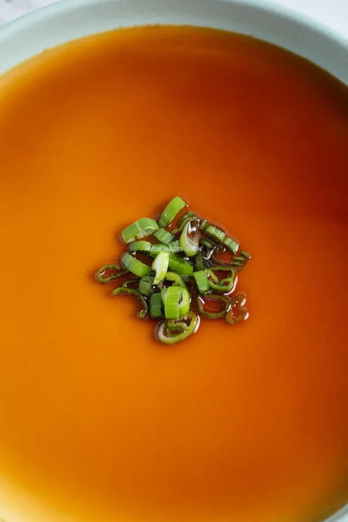 adding in scallions on top of steamed eggs