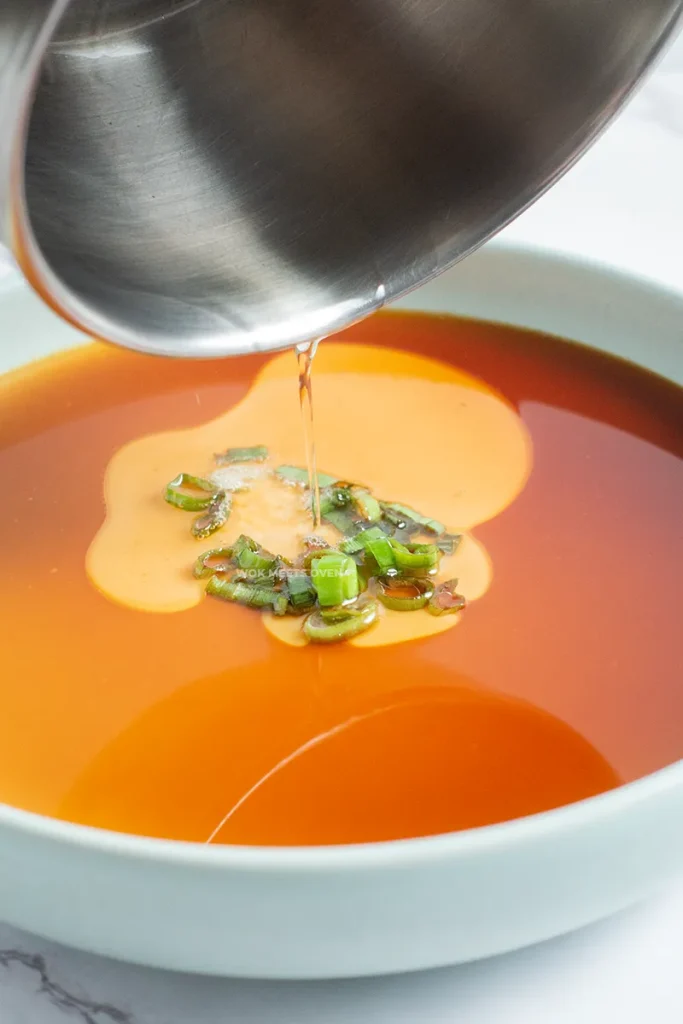 Pouring hot oil on top of eggs