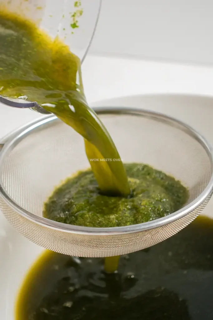 Pouring out pennywort juice into a sieve