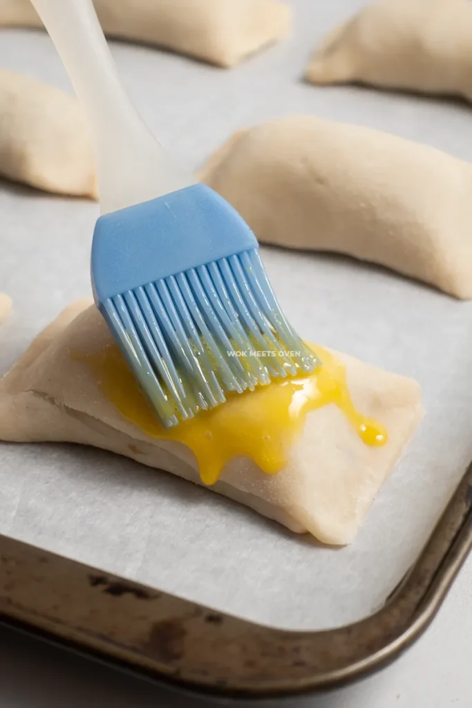 Brushing egg wash onto puff pastry