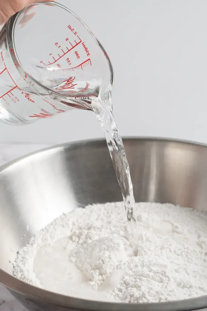 Adding in water to large bowl