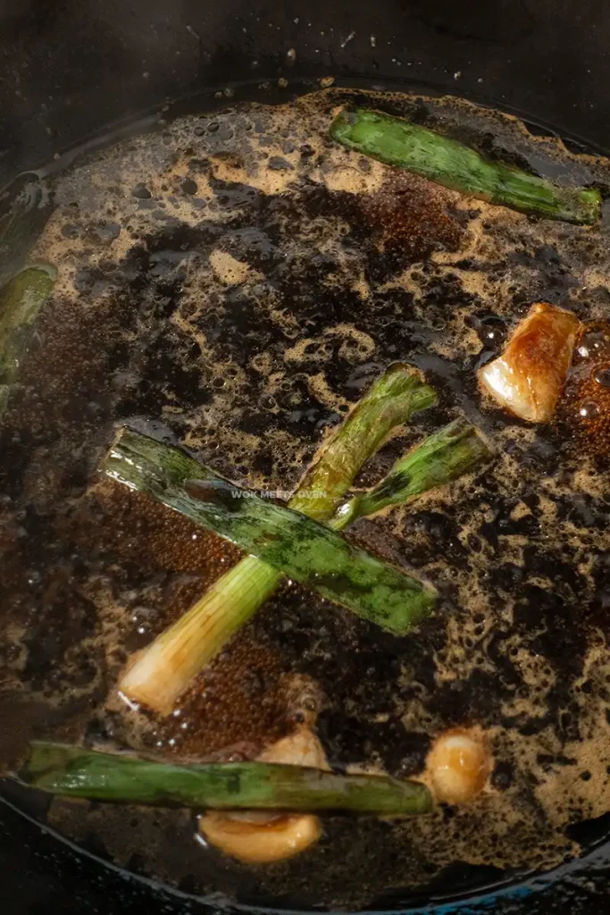 Cooking sauce with green onions and garlic in wok