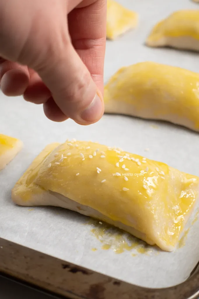 Sprinkling sesame seeds onto puff pastry