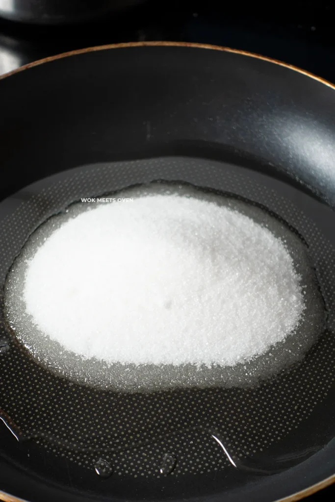 Adding sugar to oil in pan