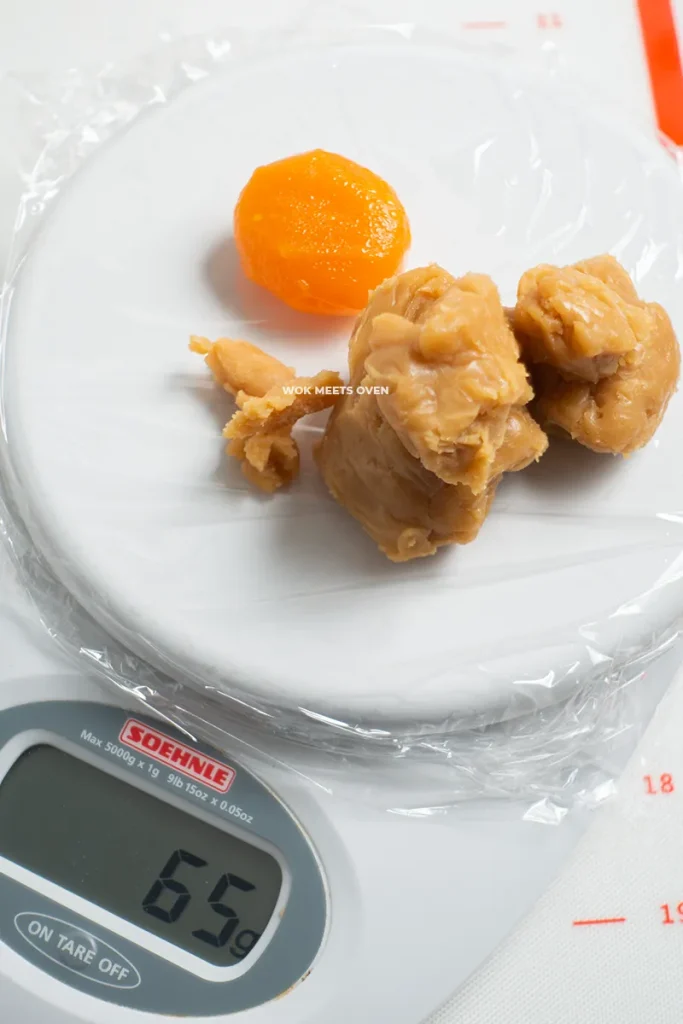 Weighing egg yolks with lotus paste on scale
