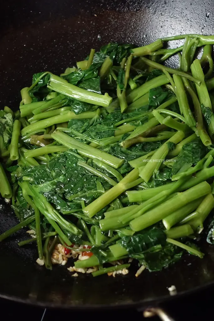 Adding back water spinach to wok
