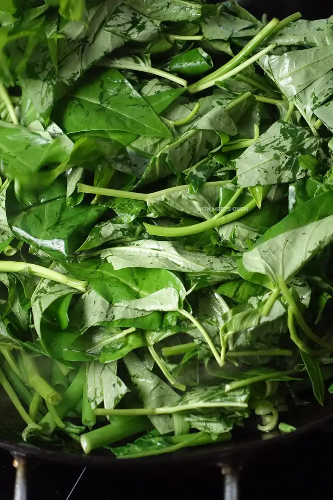 Adding in Ong choy leaves to wok