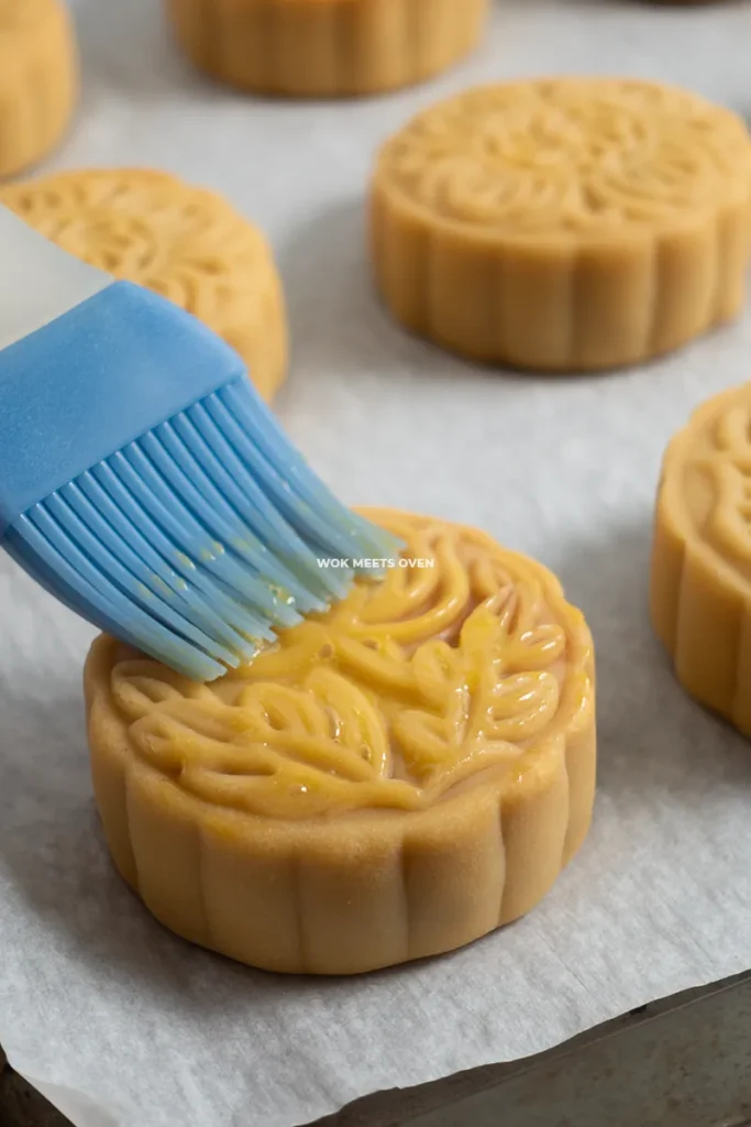 Brushing egg wash onto mooncakes