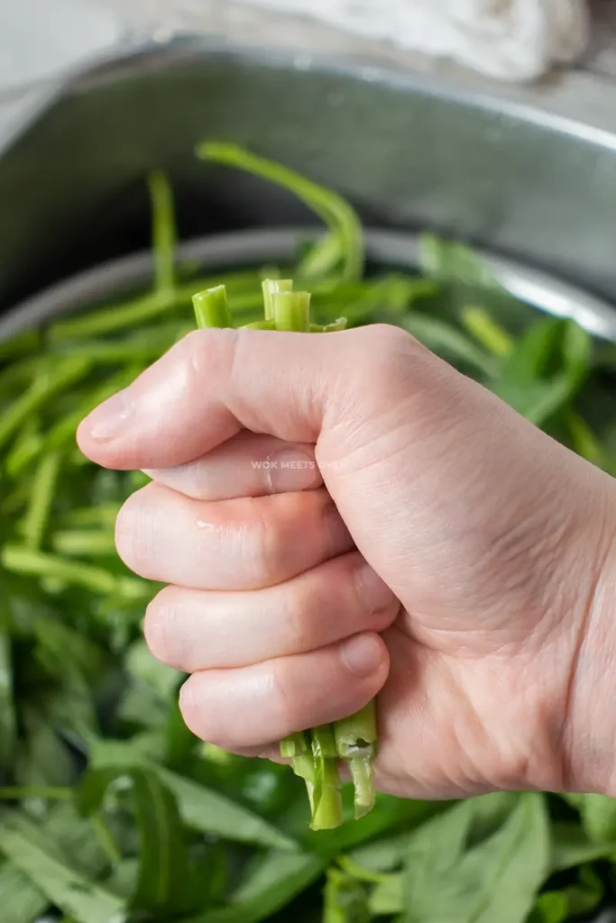 Crushing water spinach with hands