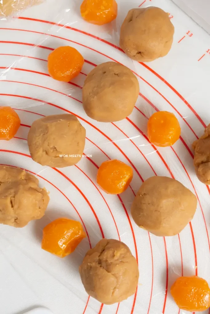 Lotus paste rolled into balls beside egg yolks