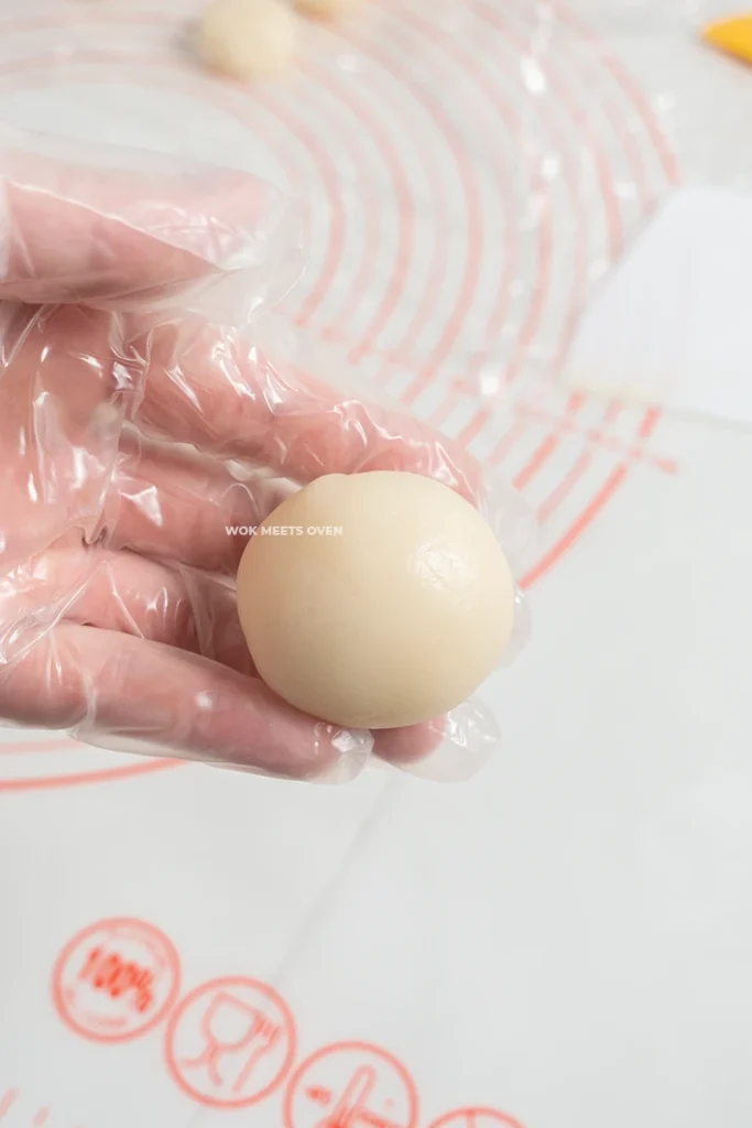 Hand holding finished shaped snow skin moon cake