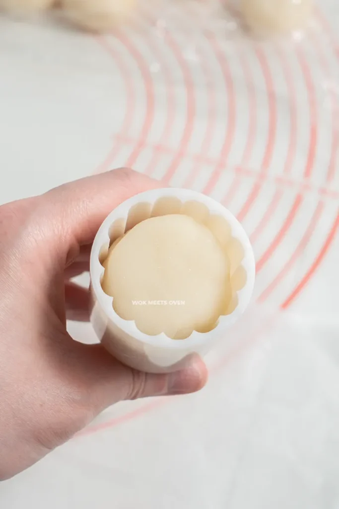 Placing moon cake ball inside of moon cake mold