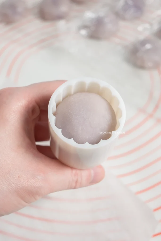 Placing snow skin mooncake inside of mooncake mold