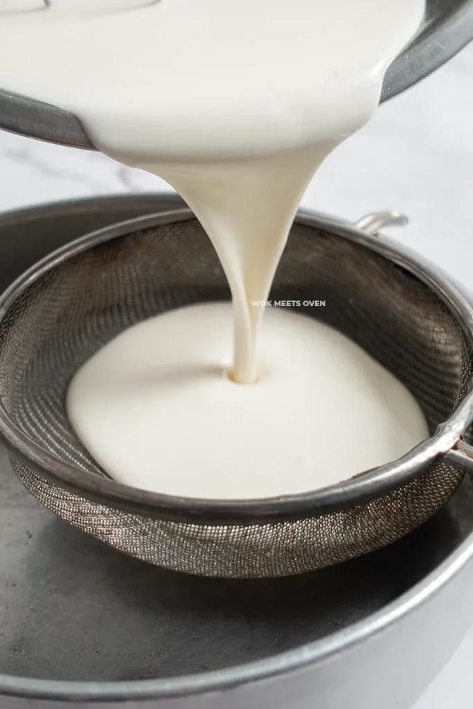 Straining snow skin ingredients through a sieve