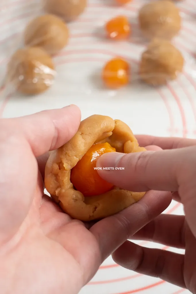 Wrapping lotus paste on top of egg yolk