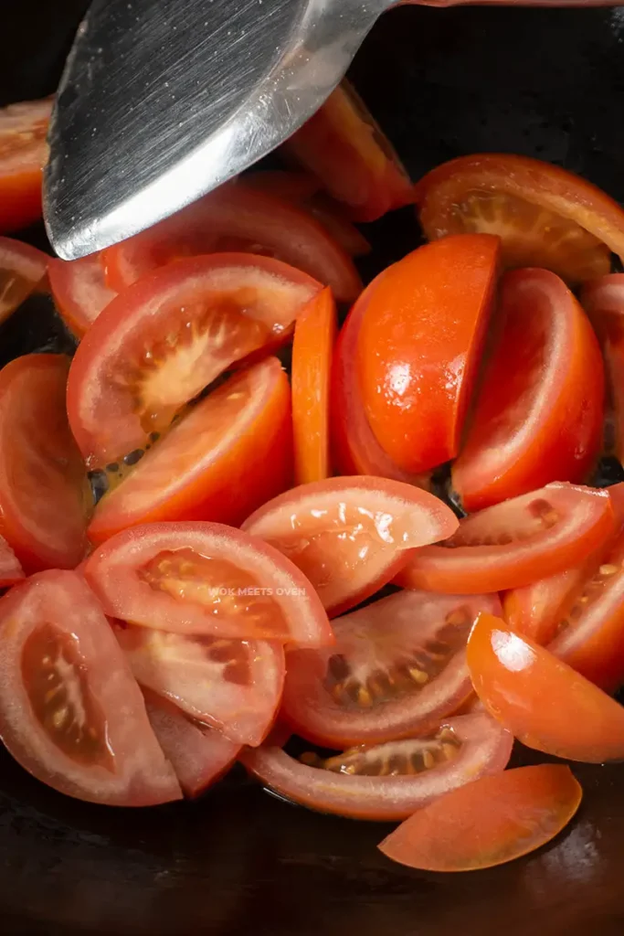 Tomatoes added to wok