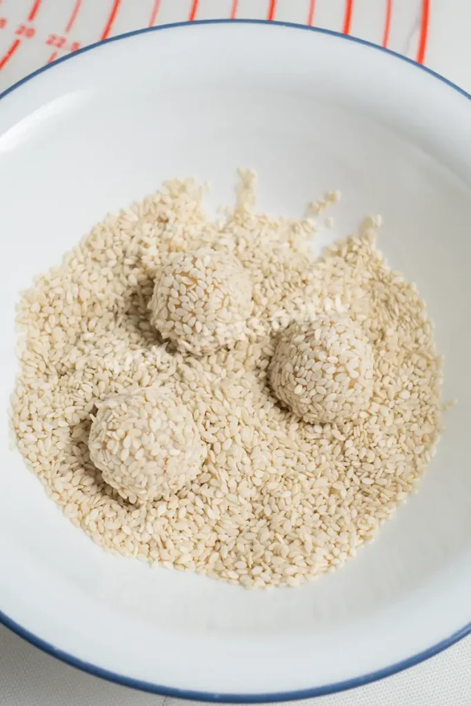 Covering dough balls with sesame seeds