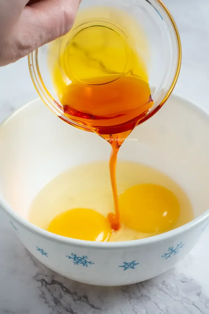 Adding in annatto oil to eggs