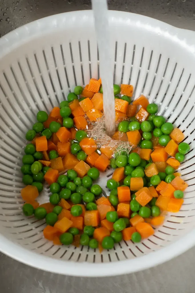 Running blanched vegetables under cold running water