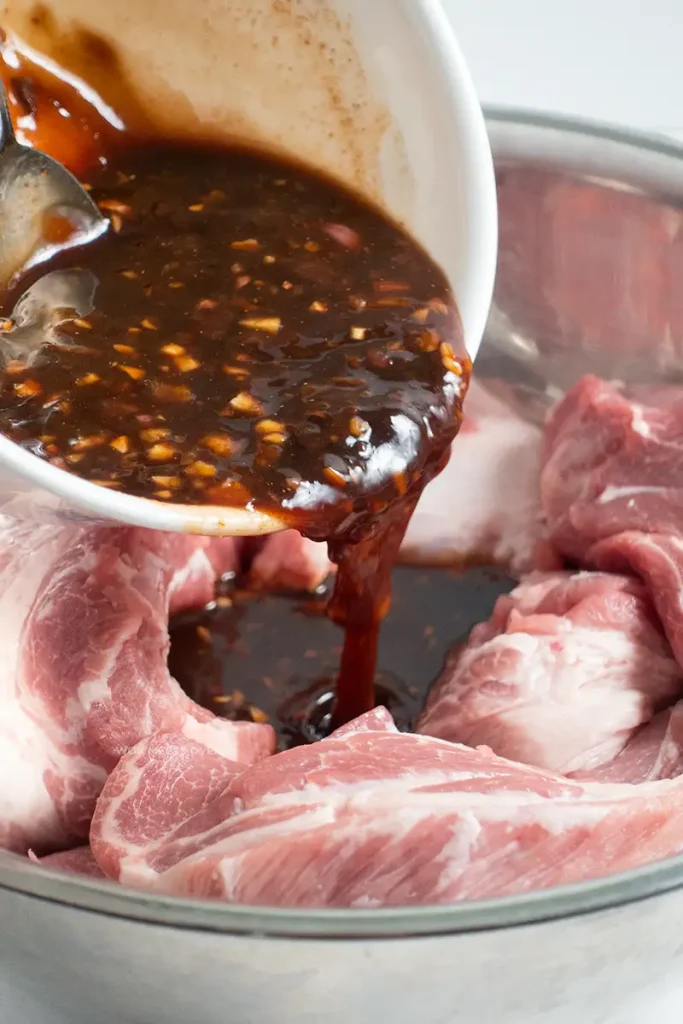 Pouring marinade into pork shoulder