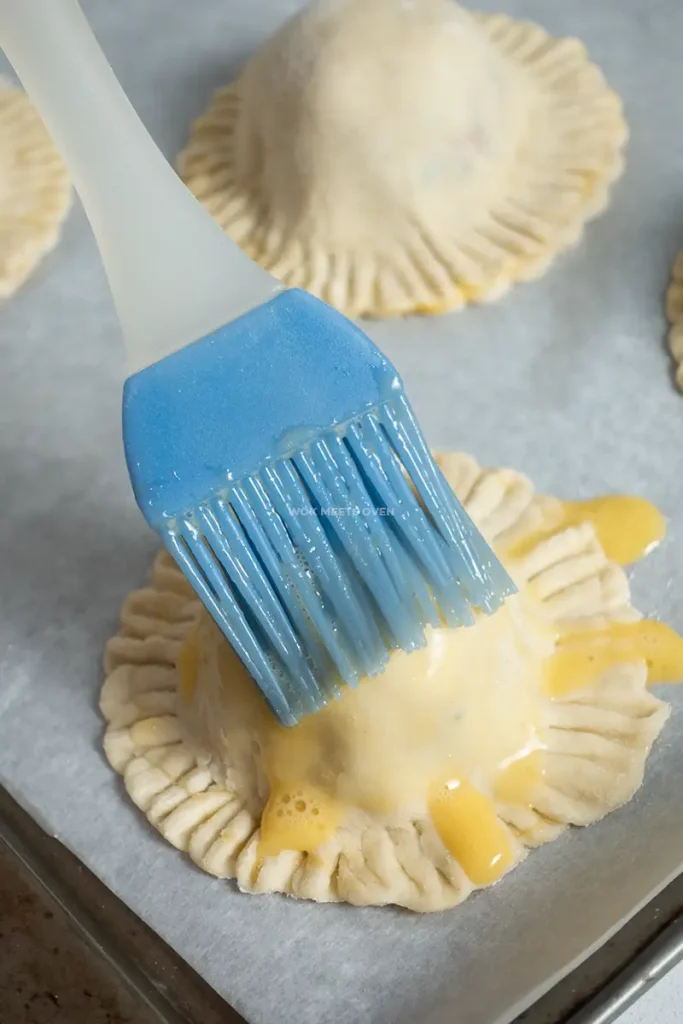 Brushing egg wash onto pate so