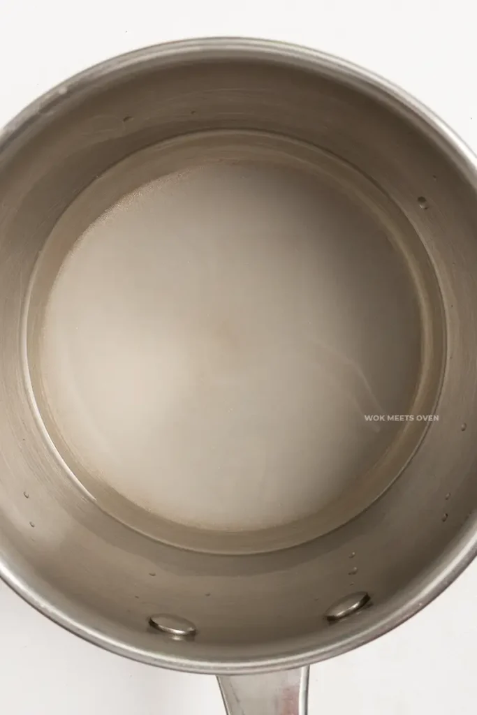 Sugar and water inside of saucepan