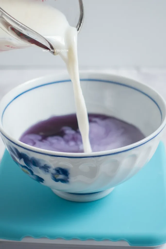Pouring in milk to purple liquid