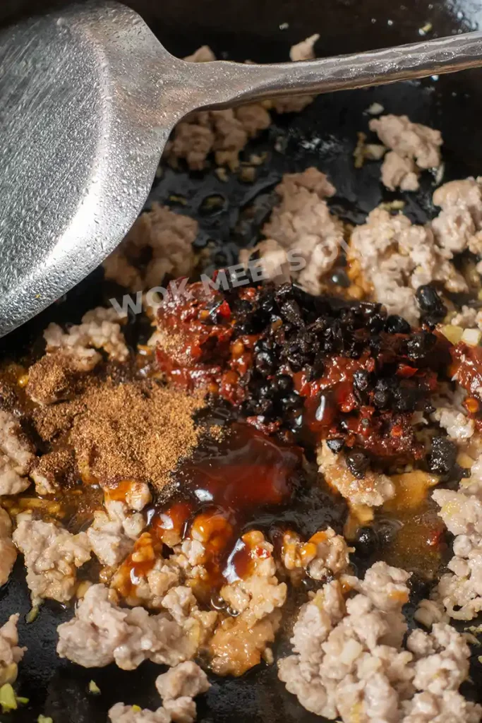 Adding in seasoning to ground pork