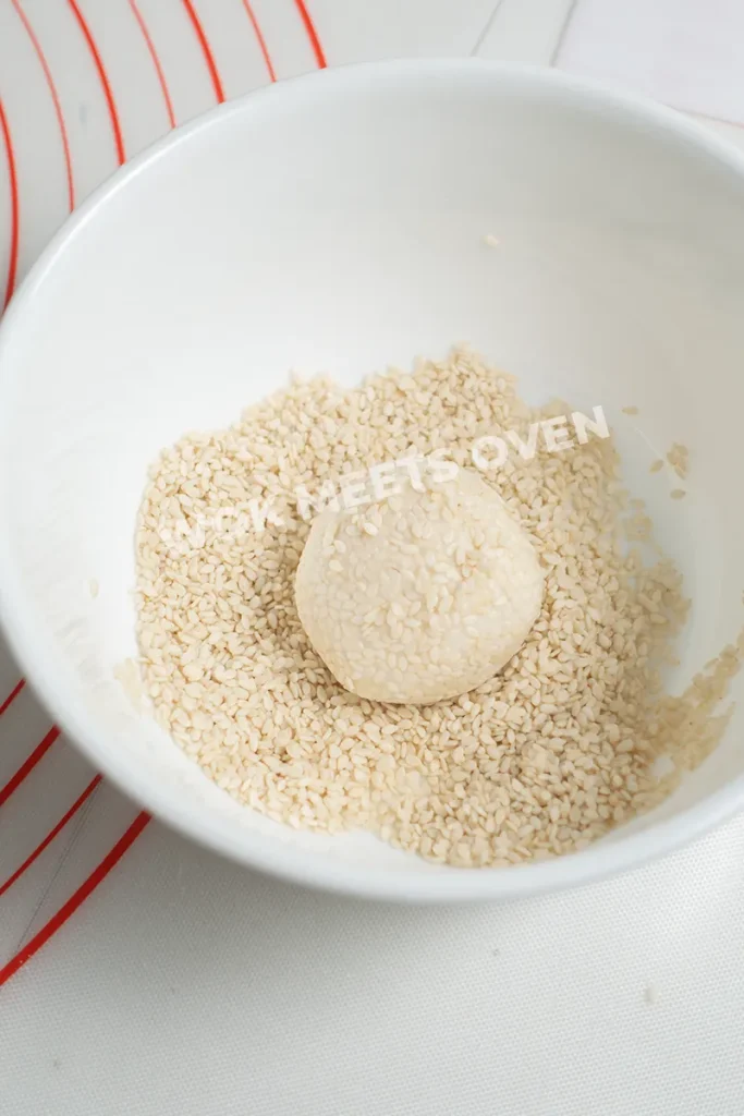 Coating dough ball with sesame seeds