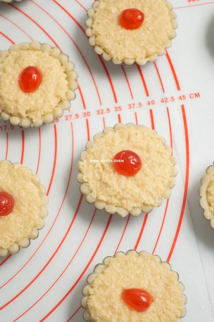 Cherry added to top of coconut tart